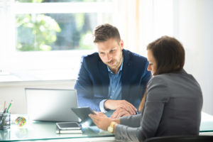 Two business people sitting across from each other at a desk